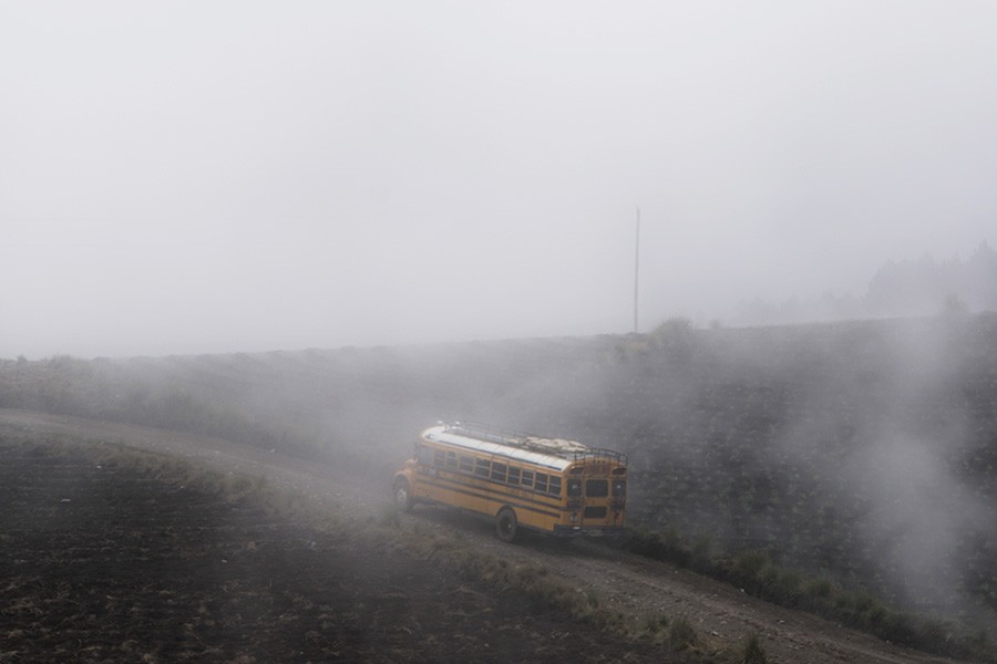 Školský autobus emitujúci výfukové plyny počas jazdy
